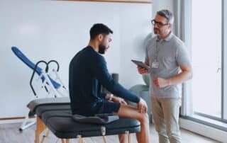 Sports physical therapist working with an athlete on strength, balance, and mobility exercises to prevent injuries and improve athletic performance